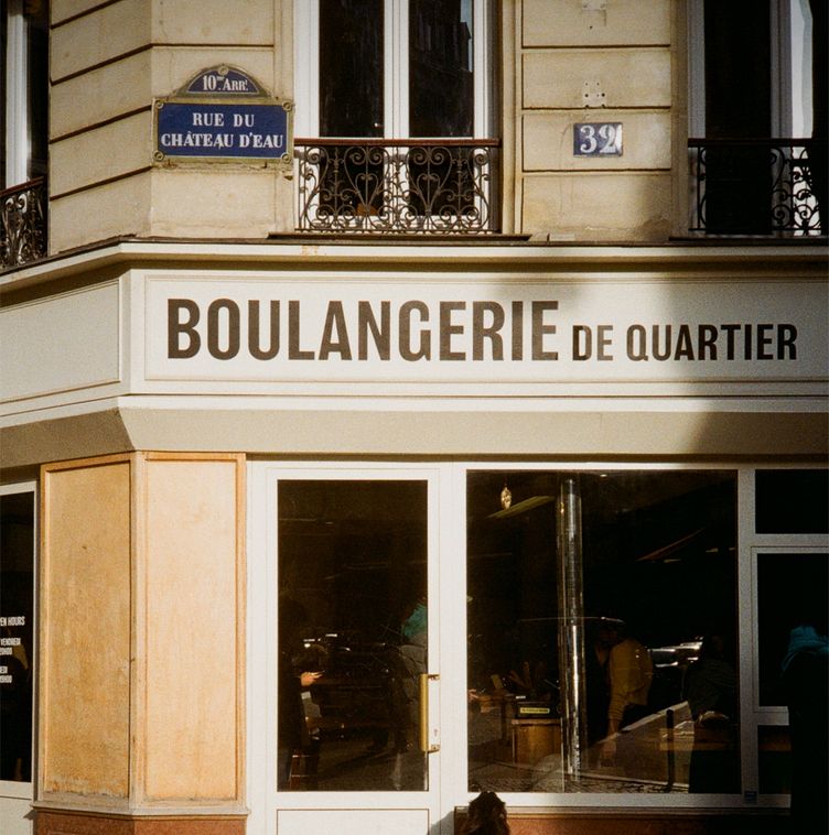 Traditional Parisian bakery with a dog outside on Rue du Château d'Eau, Paris.